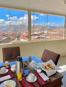 a table with food and a view of the mountains at Hostal Casona Arrambide in Cusco