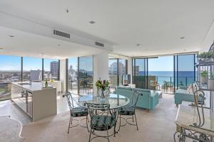 an open living room with a table and chairs at Ambience on Burleigh Beach in Gold Coast