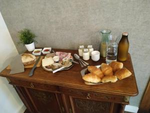 ein Tisch mit Brot und anderen Lebensmitteln darauf in der Unterkunft Le Mayou in Mortroux