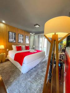 1 dormitorio con 1 cama grande con manta roja en Flame Hotel Boutique Canela, en Canela