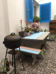 a picnic table with a grill and potted plants at Fluida - Pocitos in Montevideo