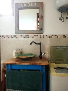 un bancone della cucina con lavandino e specchio di Viudita del Diablo a Punta Del Diablo