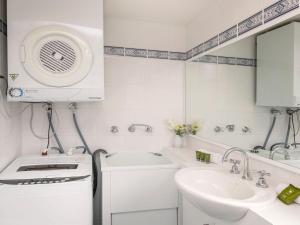un pequeño baño blanco con lavabo y lavabo en Cascades 18 3 Kurrajong Street, en Jindabyne 5 fotos más