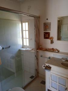 a bathroom with a glass shower and a sink at Casa Tiradentes - Apto 2 in Tiradentes +16 photos