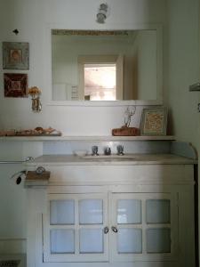 a bathroom with a sink and a mirror at Casa Tiradentes - Apto 2 in Tiradentes