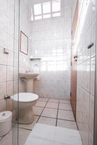 a bathroom with a toilet and a sink at Pousada Caminho das Aguas in Brotas