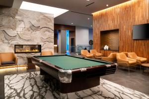 a pool table in a room with a fireplace at Hyatt House LAX Century Blvd in Los Angeles