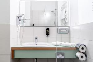 a bathroom with a sink and a mirror at 24seven Apartments - Self Check-IN in Landshut