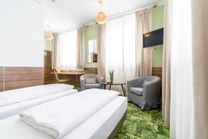 Habitación de hotel con 2 camas y 2 sillas en 24seven Apartments - Self Check-IN, en Landshut