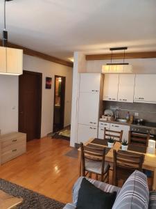 een keuken en een woonkamer met een tafel en een eetkamer bij APARTMENTS FOKA & SPA - 600m from Gondola ski lift in Kopaonik