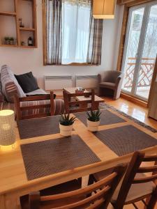 een woonkamer met een houten tafel en stoelen bij APARTMENTS FOKA & SPA - 600m from Gondola ski lift in Kopaonik