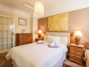 a bedroom with a large white bed with two night stands at La Plage in Deal