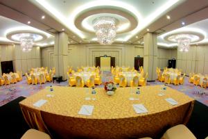 una grande sala banchetti con un grande tavolo e sedie di Swiss-Belhotel Ambon a Ambon
