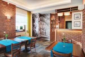 a dining room with blue tables and chairs and a brick wall at Hotelik B&B Pod Dębami in Radwanice