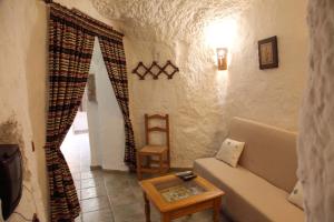 een woonkamer met een bank en een tafel bij Cuevas La Atalaya in Huéscar
