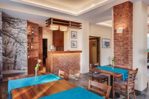 une salle à manger avec deux tables et un mur en briques dans l'établissement Hotelik B&B Pod Dębami, à Radwanice