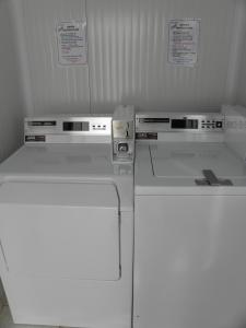 twee witte apparaten in een keuken met borden op de muur bij St. Lazaros House in Larnaka