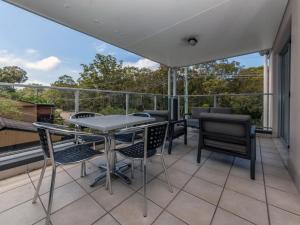a patio with chairs and a table on a balcony at Shoal Bay Beach Apartments Unit 17 2 Shoal Bay Road in Nelson Bay