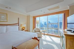 Crowne Plaza Qingdao, an IHG Hotel في تشينغداو: غرفة فندقية بسرير ونافذة كبيرة