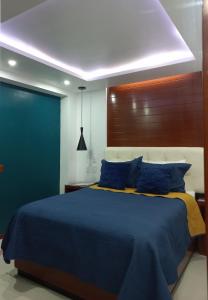 1 dormitorio con cama azul y almohadas azules en La Aurora Hotel Like Home en Huamantla