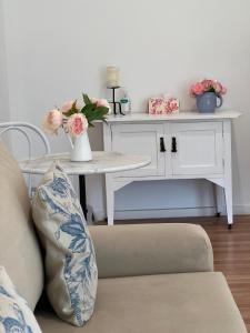 a living room with a couch and a table with flowers at Birchwood Cottage in Yarck