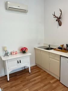 a white kitchen with a sink and a counter at Birchwood Cottage in Yarck