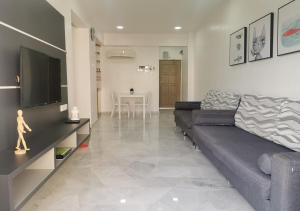 a living room with a couch and a television at 1-6Pax Port Dickson 2BR Glory Beach Resort Seaview in Port Dickson