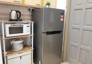 a refrigerator in a kitchen with a microwave on a shelf at 1-6Pax Port Dickson 2BR Glory Beach Resort Seaview in Port Dickson