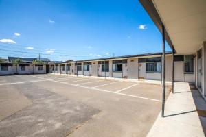 an empty parking lot in front of a building at Nightcap at Sandbelt Hotel in Moorabbin