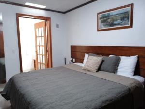 a bedroom with a large bed with a wooden headboard at La Aurora Hotel Like Home in Huamantla
