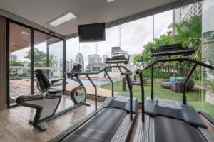 a gym with two treadmill machines and a large window at Grand Asoke Suites Boutique Residence in Bangkok