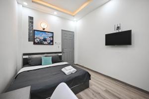 a bedroom with a bed and a flat screen tv at Bear's House - The Riverside in Ho Chi Minh City