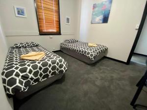 2 Betten in einem Zimmer mit schwarzen und weißen Bettdecken in der Unterkunft Imperial Hotel Coonabarabran in Coonabarabran