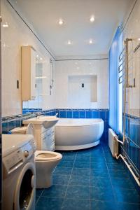 a bathroom with a tub and a toilet and a sink at Piterstay Apartments - Saint Petersburg in Saint Petersburg