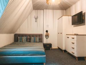 een slaapkamer met een bed, een tv en een dressoir bij Leśny Zakątek Borkowo in Borkowo