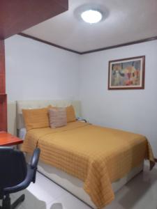 a bedroom with a bed and a desk and a chair at La Aurora Hotel Like Home in Huamantla