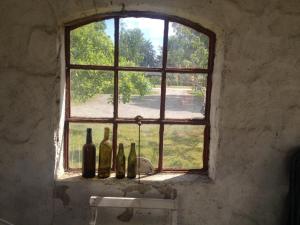 an old window with bottles sitting on a ledge at Strandbadsgården B&B in Löderup +42 photos