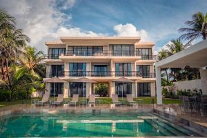 a building with a swimming pool and a resort at ApartHotel Ebb Ti Kaan Tulum-Luxury Condos- in Tulum