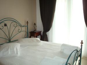 a bedroom with a bed with white sheets and a window at Merlot Village Rental Apartments in Kariá