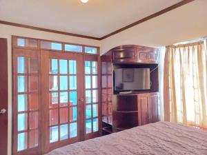a bedroom with a bed and a tv and sliding glass doors at Hotel La Aurora Like Home in Huamantla