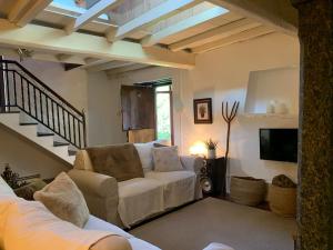 a living room with a white couch and a tv at Casa Castro de Crecente in Valdoviño
