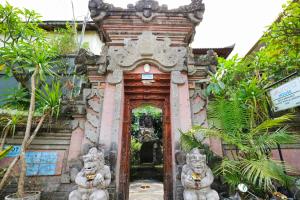 een tempel met twee standbeelden voor een deuropening bij Aurora House in Ubud