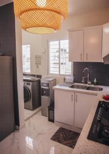 a kitchen with a sink and a dishwasher at Luxury Apt. With Rooftop in the Heart of San Juan in SJM