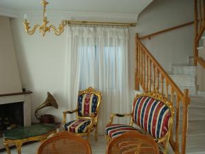 a living room with two chairs and a staircase at Merlot Village Rental Apartments in Kariá