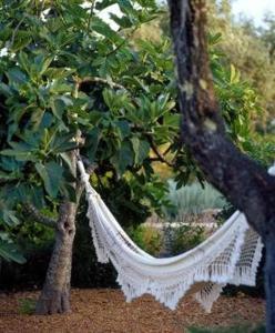 a hammock hanging from a tree in a garden at Quinta da Lua in Tavira