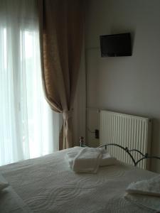 a bedroom with a bed and a window with a television at Merlot Village Rental Apartments in Kariá