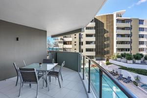 a patio with a table and chairs on a balcony at Ambience on Burleigh Beach in Gold Coast