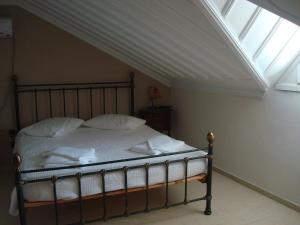 a bedroom with a bed with a skylight at Merlot Village Rental Apartments in Kariá