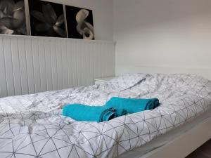 Una cama con una manta azul encima. en Latinerkvarteret, en Viborg