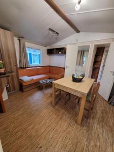 een woonkamer met een tafel en een bank bij Camping Le Brochet in Péronne